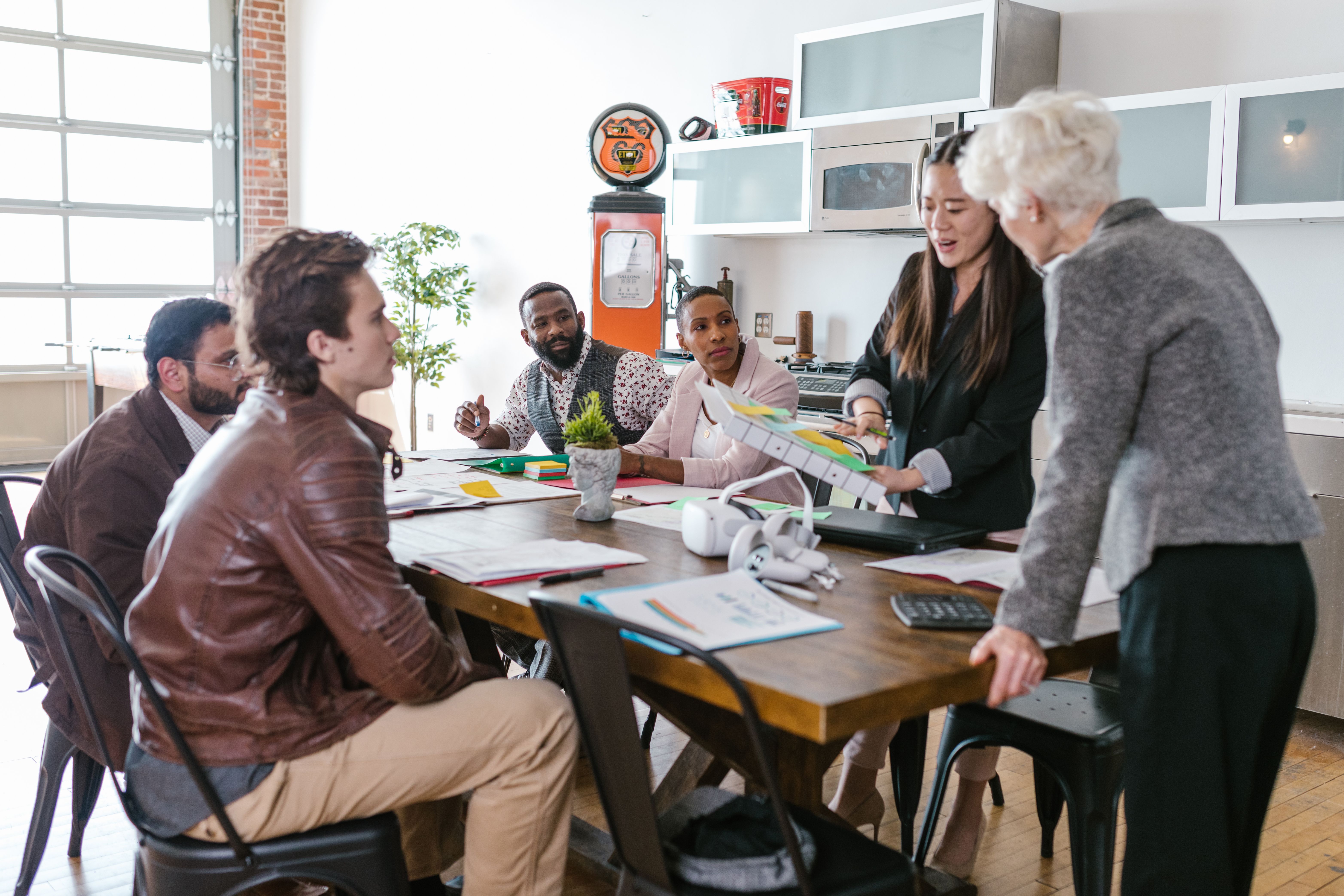 Colleagues in a collaborative business meeting discussing funding around a table
