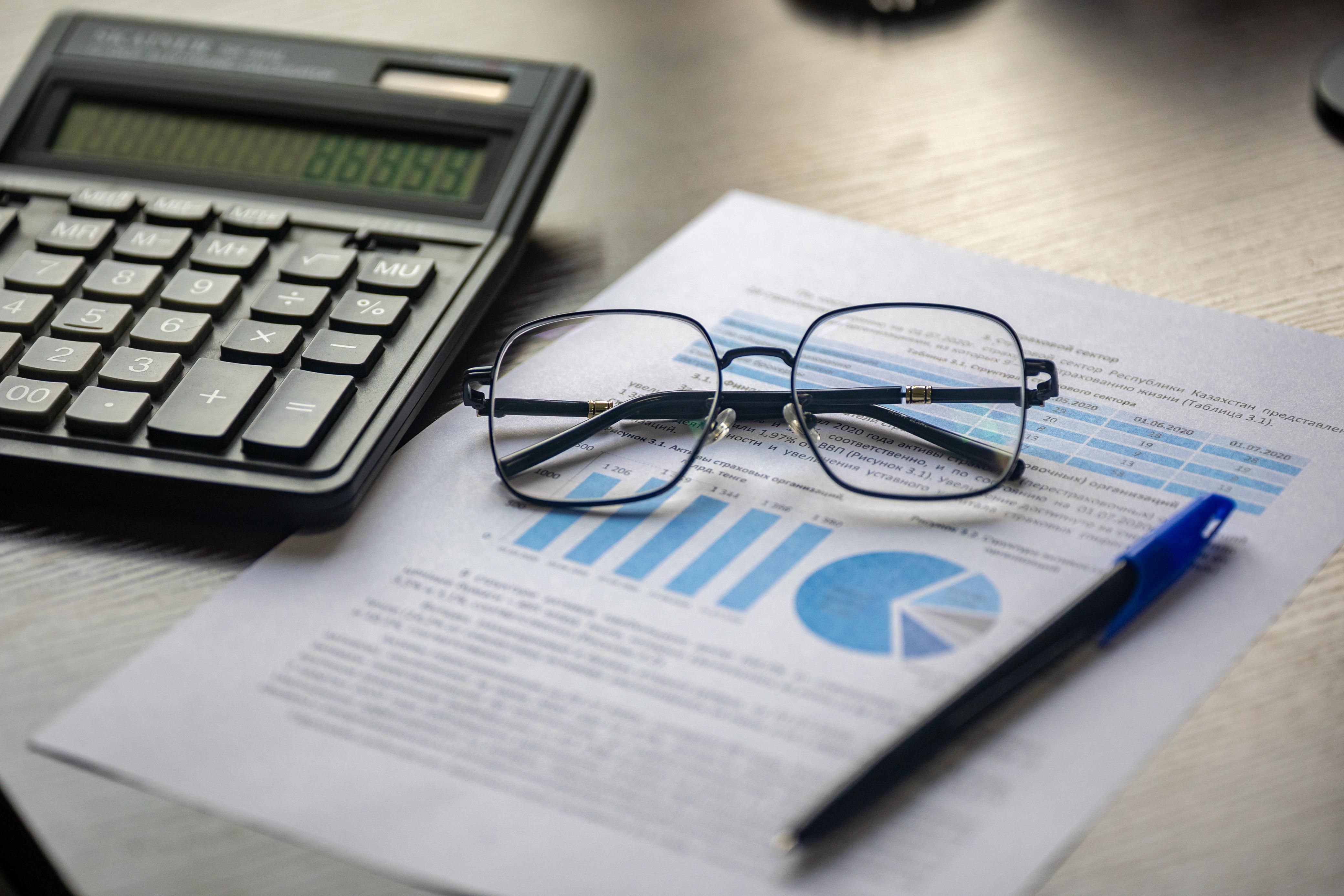 Financial document, calculator, pen, and glasses representing accessible financial data.