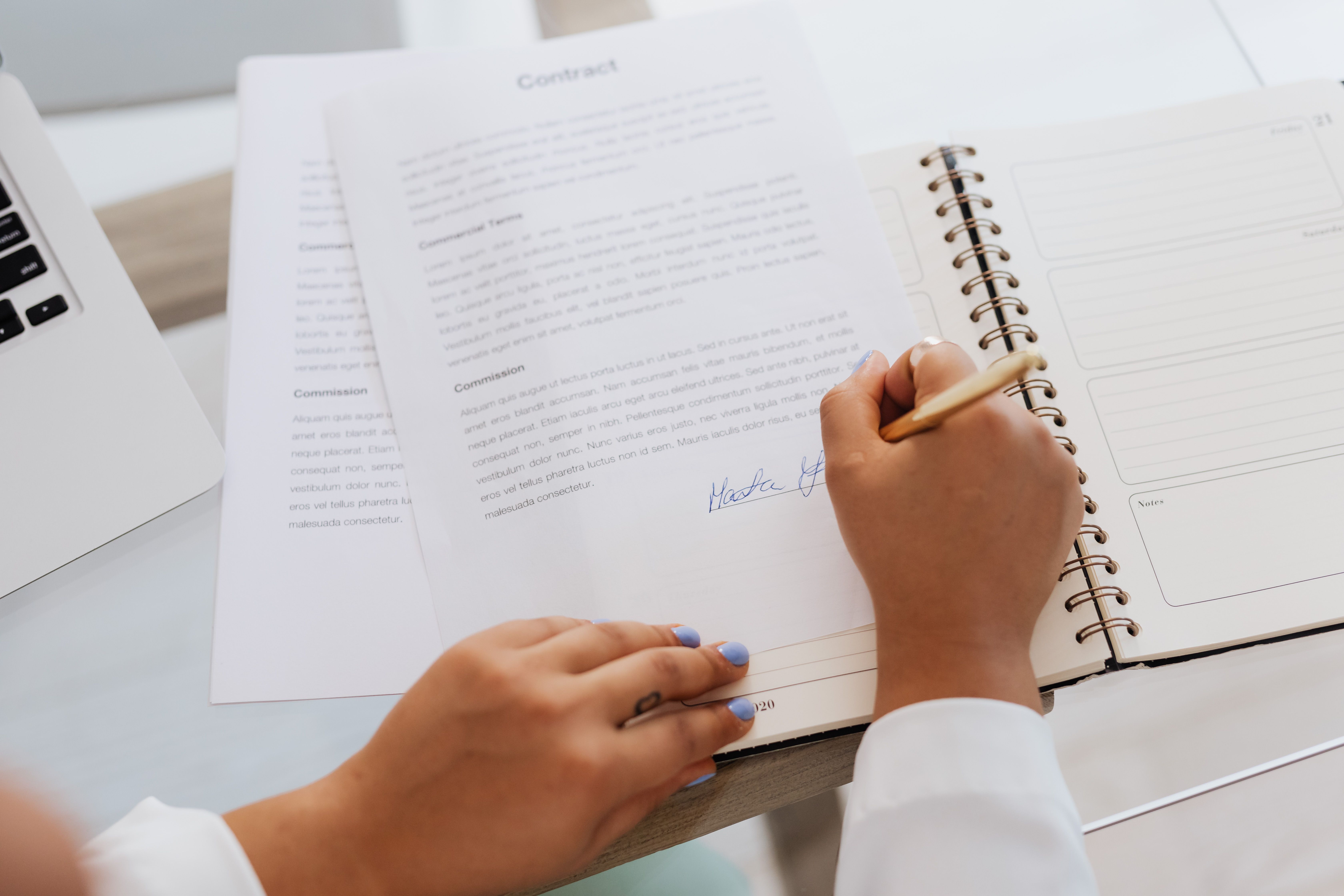 Hands signing a funding agreement contract that governs litigation finance disclosure terms