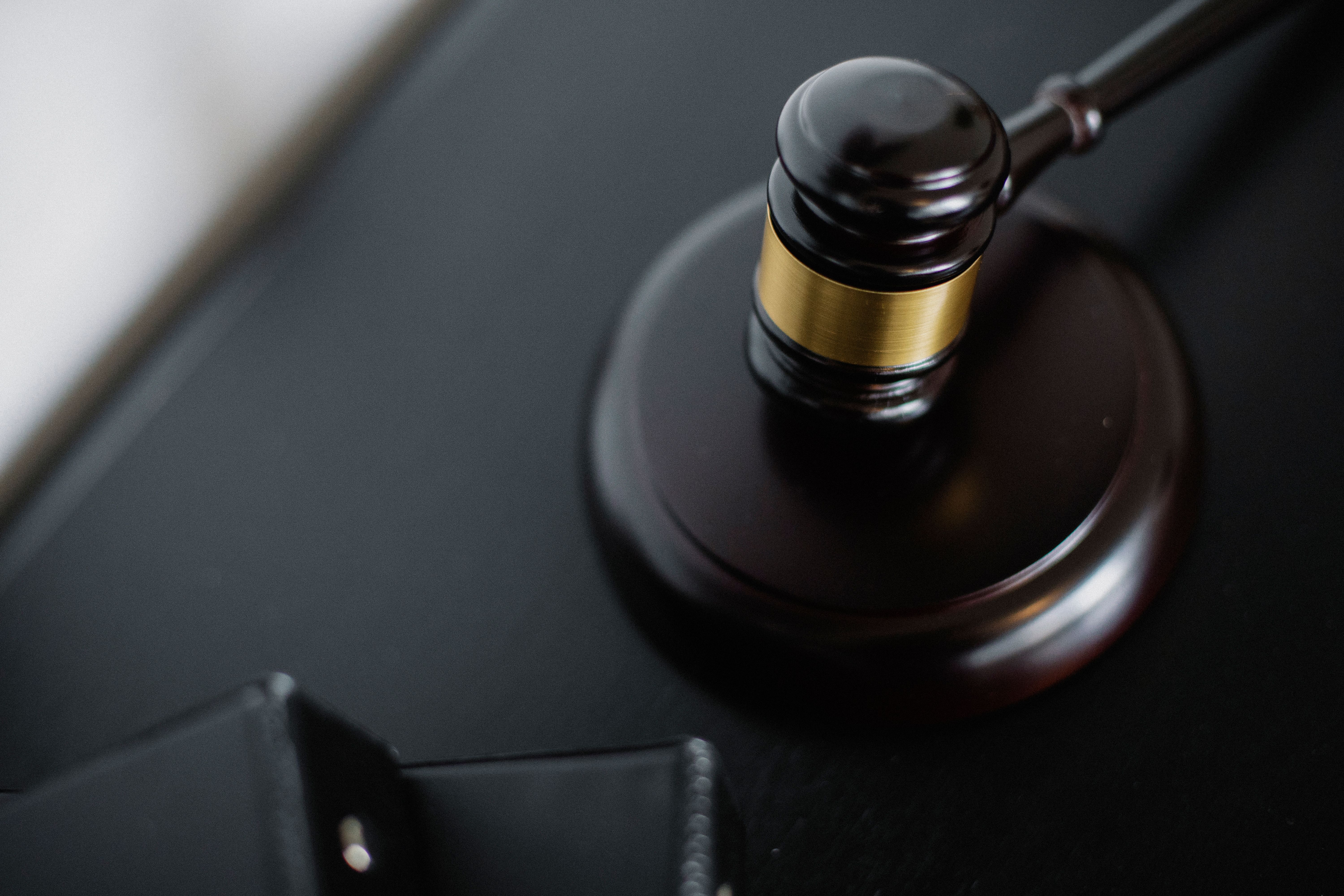 Wooden gavel and case folders on a courtroom table symbolizing litigation and court rules