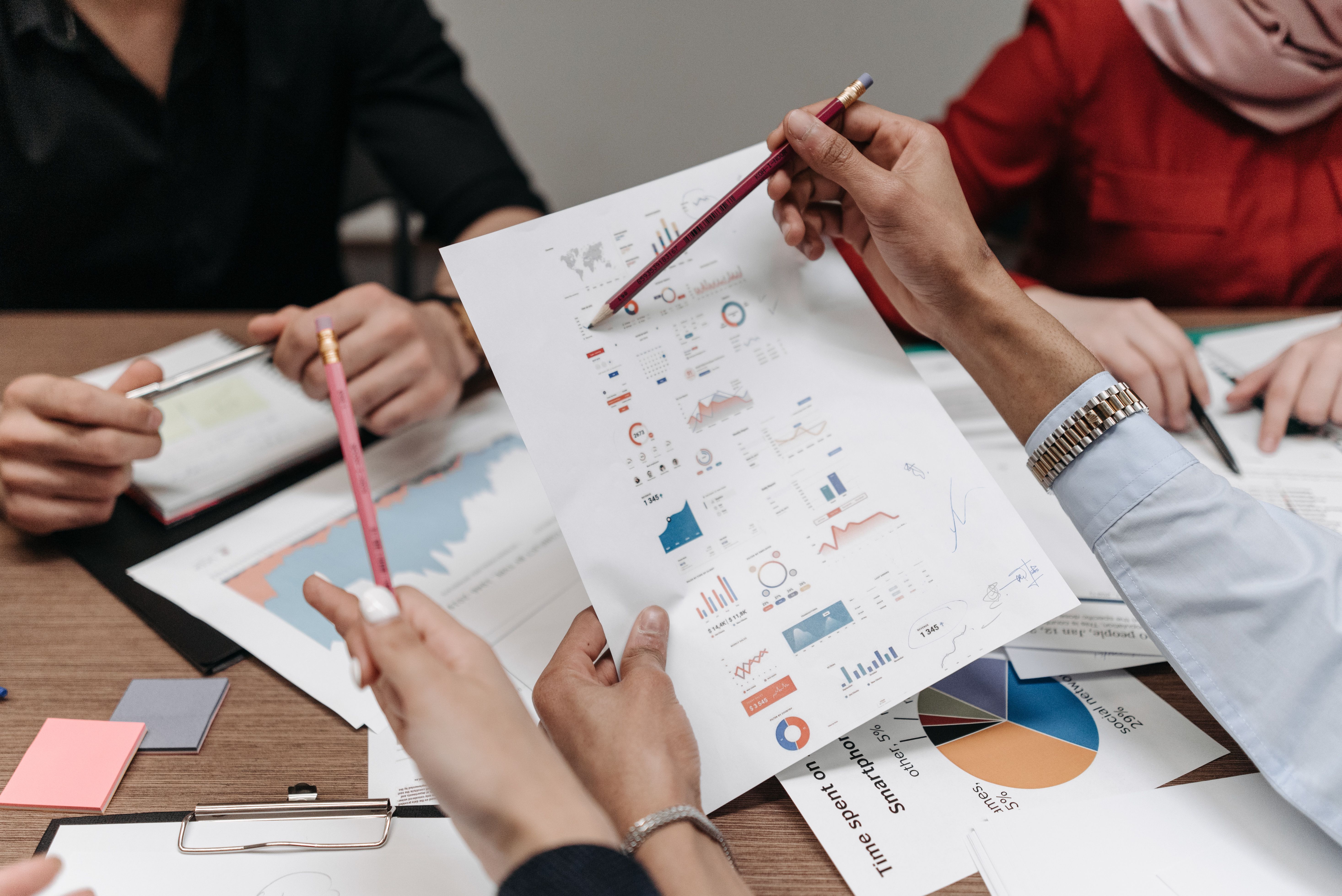 Team analyzing business reports and charts during a collaborative meeting